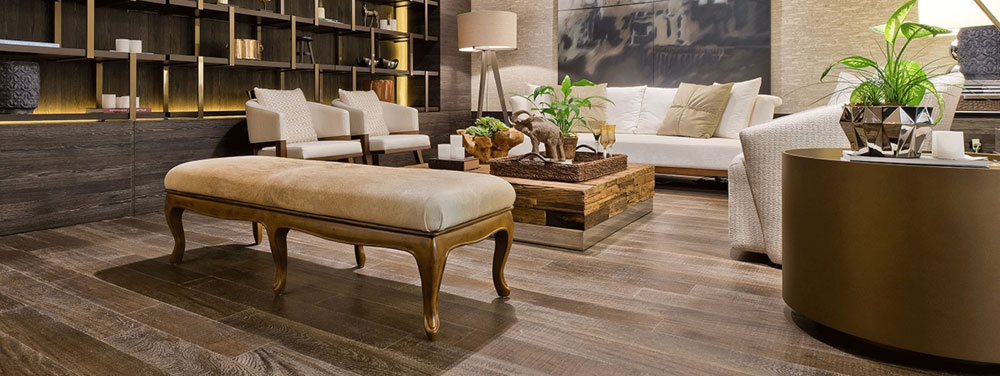 dark hardwood flooring in living room with white furniture, plants and bronze accents